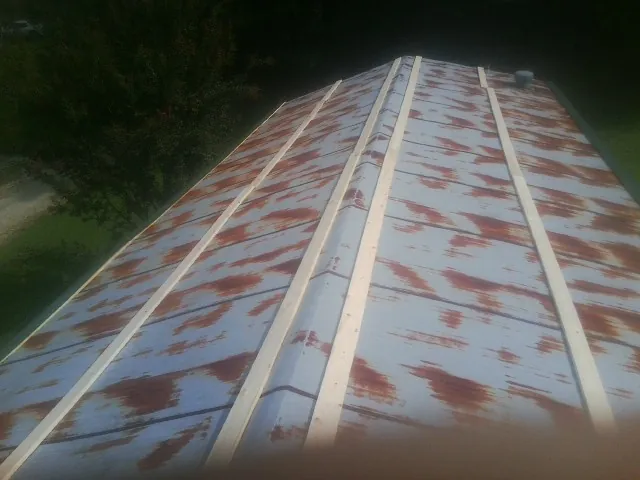 Rusted metal roof panels with new wood purlins before replacement — Storm Damage Roof Repair in Casselberry by Roofing Brothers